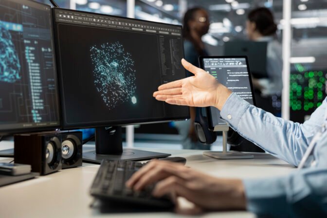 Close up of programmer looking at computer monitor in data center, managing server virtualization, running scripts. Worker using programming language on PC screen in server farm