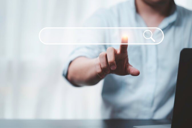 Hand touching with search icon for Search Engine Optimisation or SEO concept to find information by internet connection.